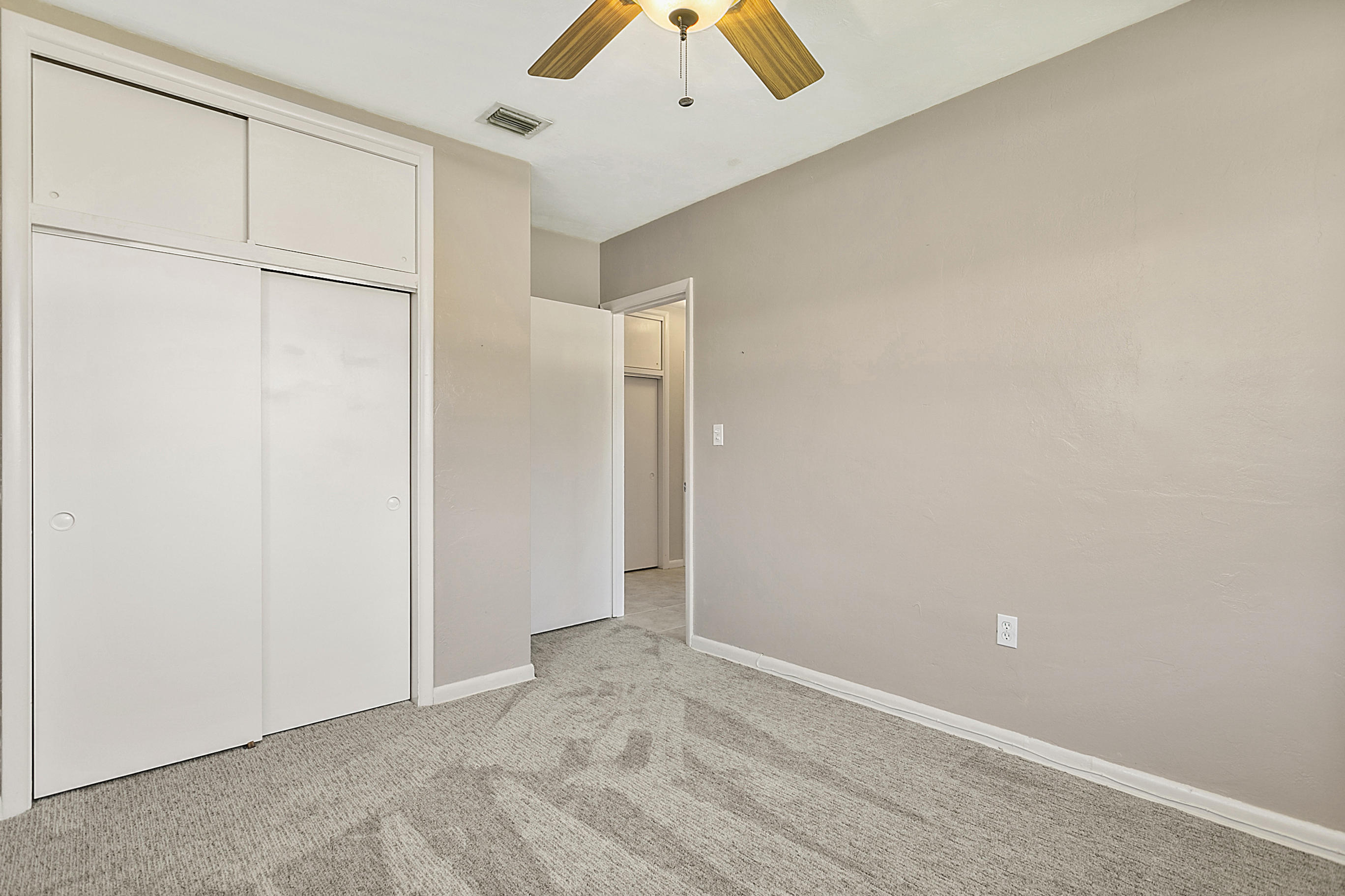 353 Shady Lane Road Palm Springs, FL 33461 - Photo 25 of 30 an empty room with a ceiling fan and wooden floor