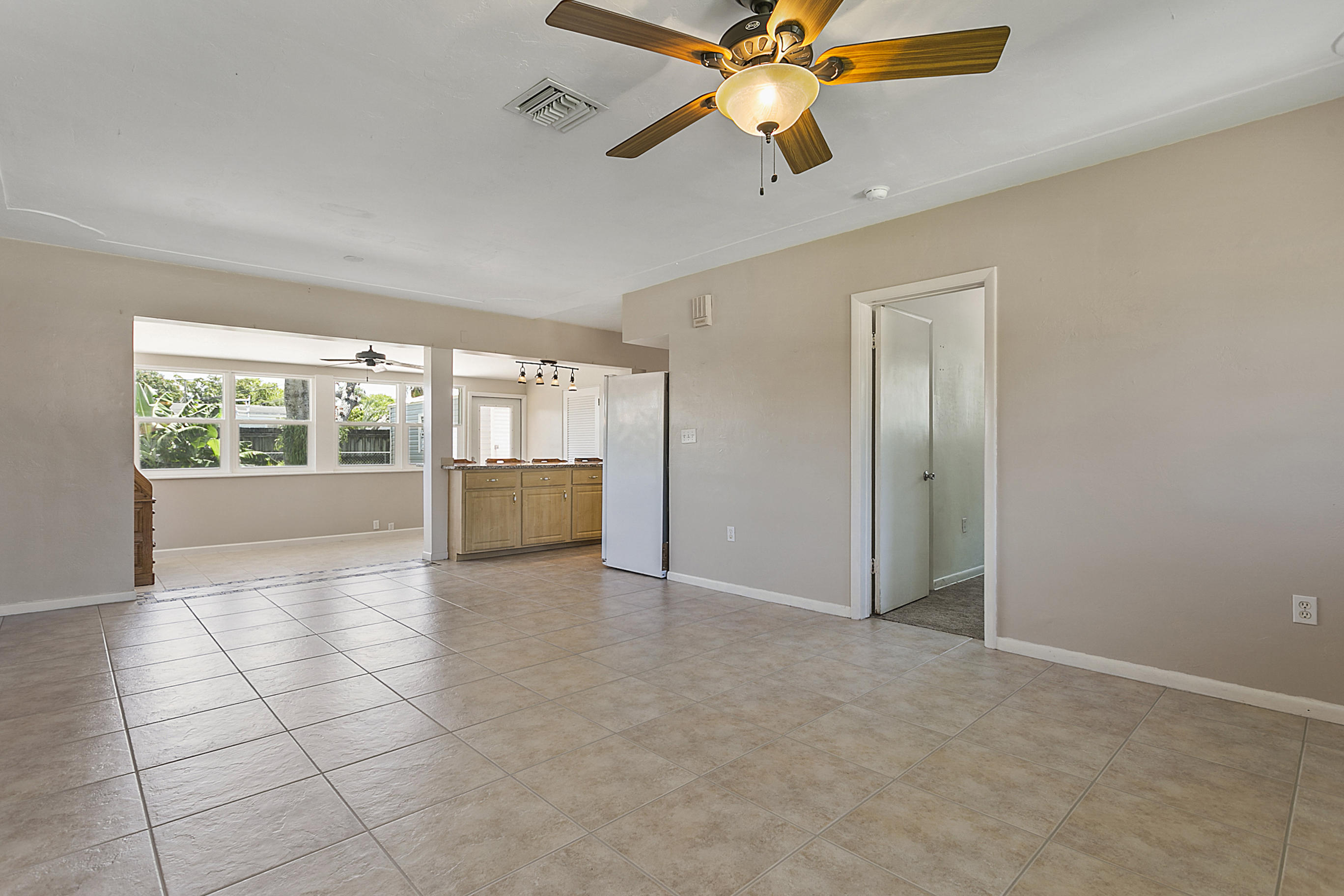 353 Shady Lane Road Palm Springs, FL 33461 - Photo 6 of 30 an empty room with chandelier fan and windows