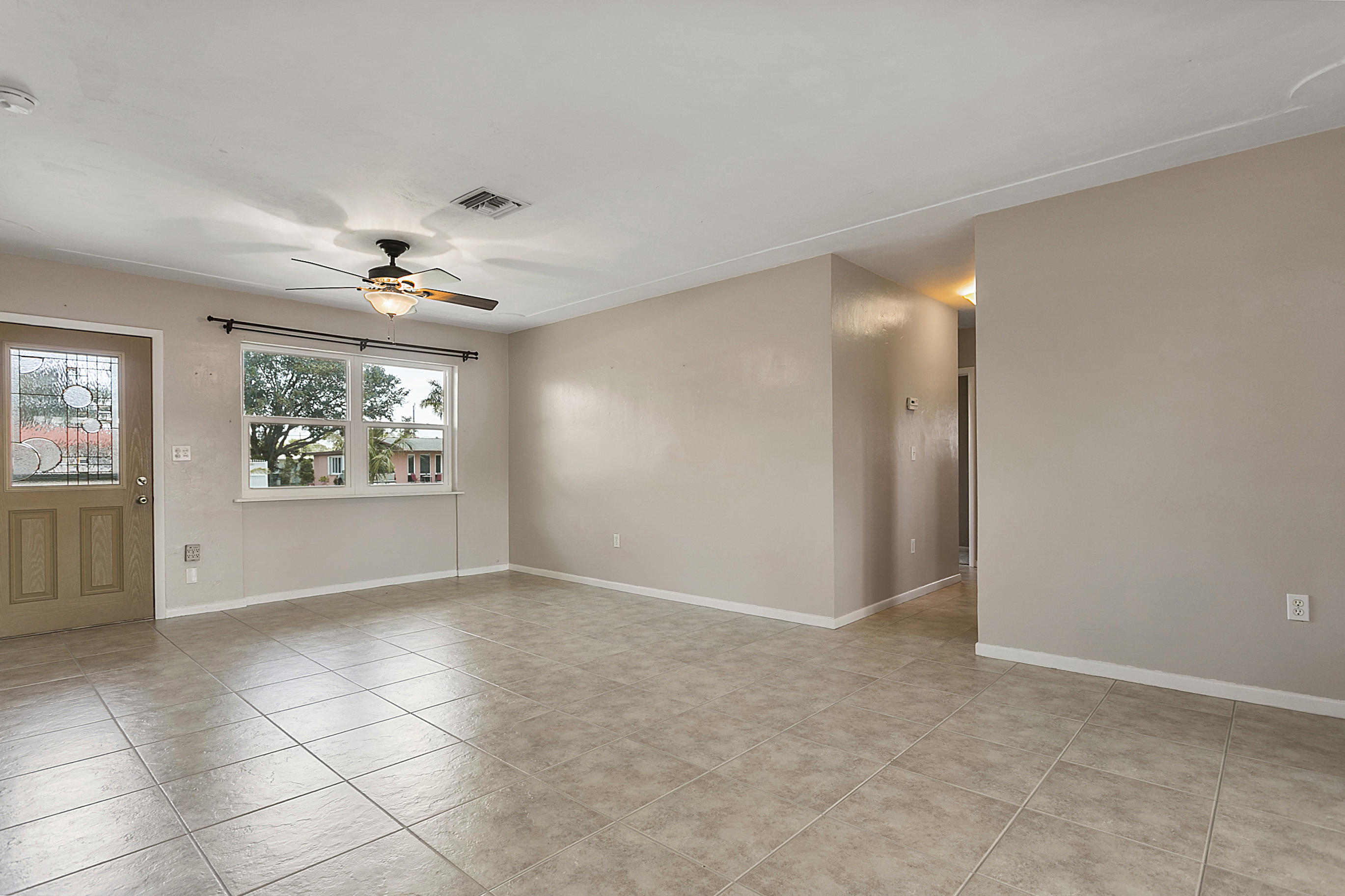 353 Shady Lane Road Palm Springs, FL 33461 - Photo 7 of 30 an empty room with windows and chandelier fan