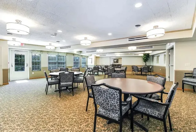 a dining hall with stainless steel appliances kitchen island granite countertop a dining table and chairs