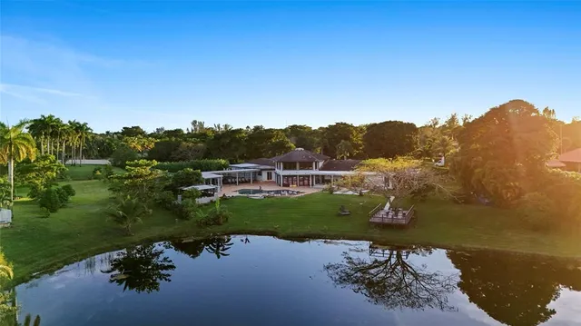 a view of a swimming pool with a lawn chairs and a fire pit