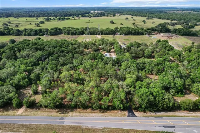 an aerial view of residential houses with outdoor space and trees