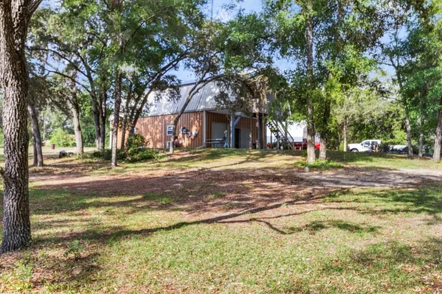 a view of a house with a yard and tree s