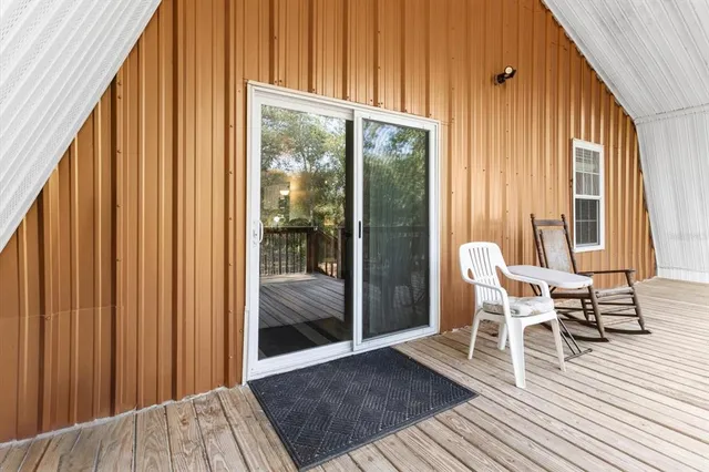 a view of a balcony with chairs and wooden floor