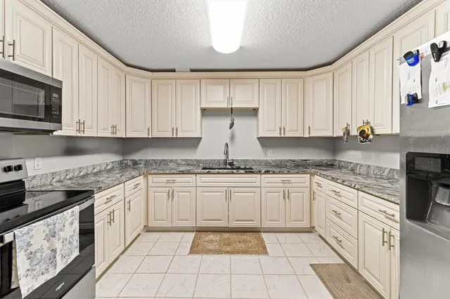 a kitchen with granite countertop white cabinets and white appliances