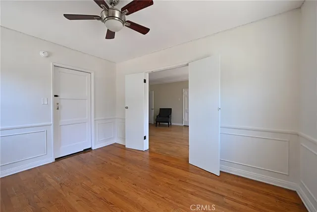a view of an empty room with wooden floor fireplace and a window