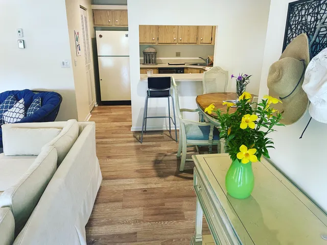 a living room with stainless steel appliances furniture a chandelier