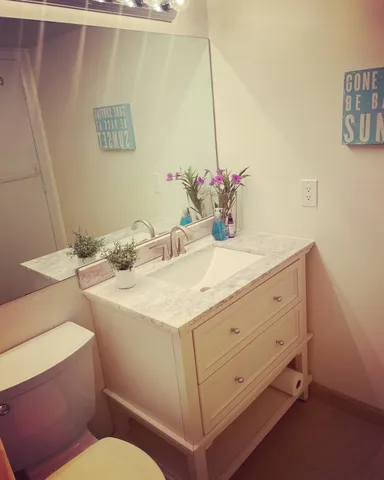a bathroom with a sink toilet and a mirror