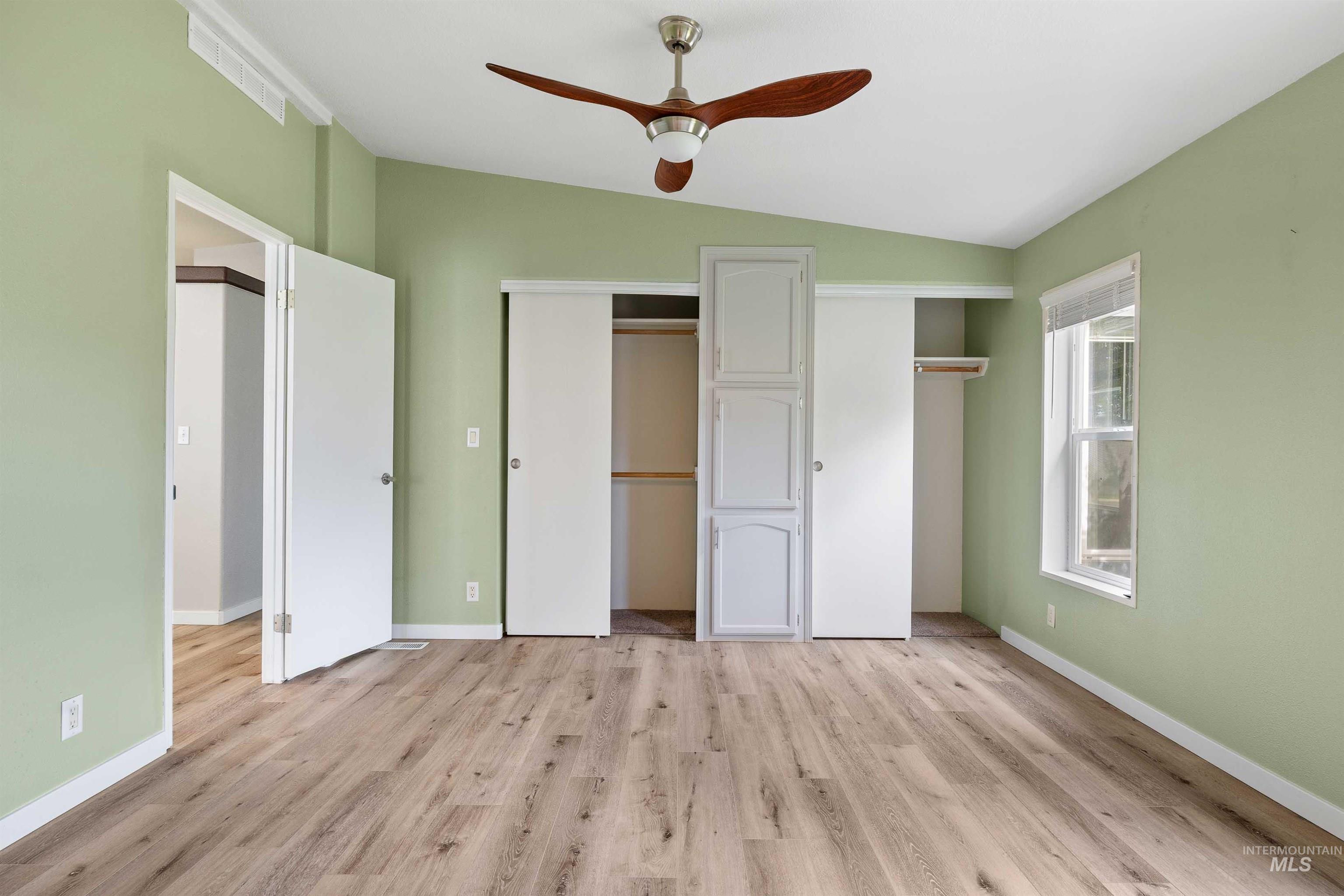 910 Moonglo, Unit 80 Buhl, ID 83316 - Photo 13 of 25 Room featuring wood-finish flooring, a vaulted ceiling, and a ceiling fan with integrated lighting
