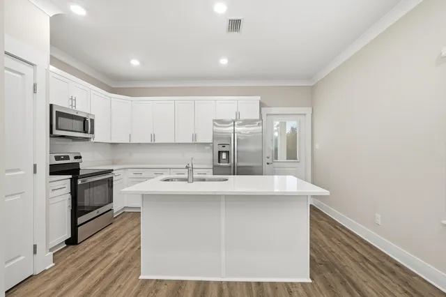 a kitchen with stainless steel appliances granite countertop a sink stove and refrigerator