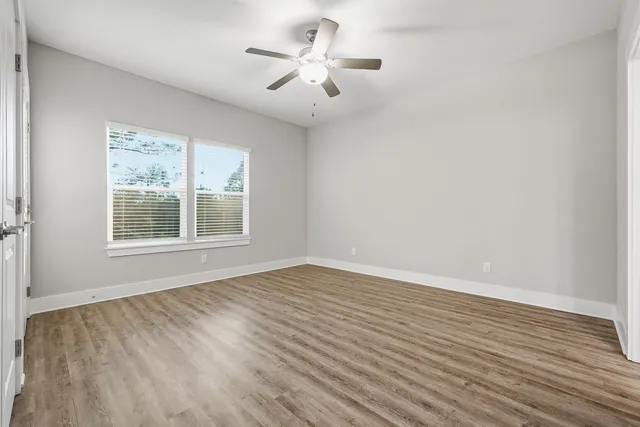 wooden floor in an empty room with a window