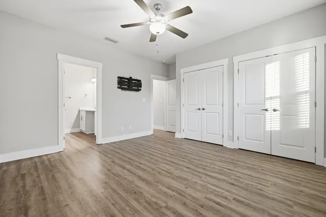 an empty room with wooden floor and windows