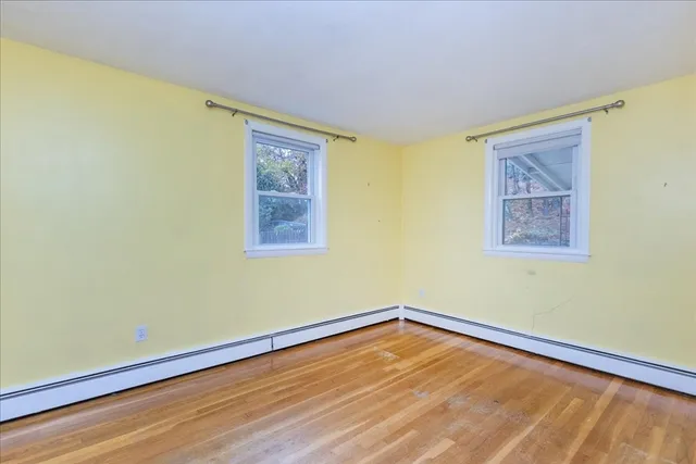 a view of a room with wooden floor and a window