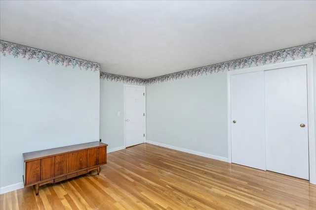 a room with a bed and wooden floor