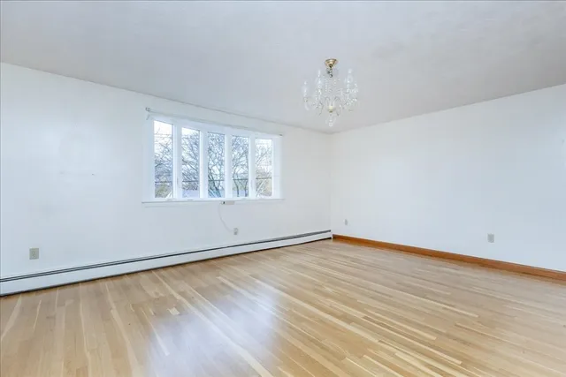 wooden floor in an empty room with a window