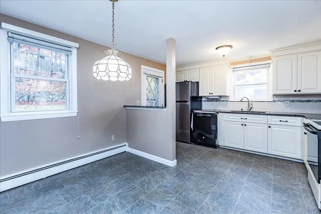 a kitchen with stainless steel appliances granite countertop a refrigerator a sink a stove and white cabinets