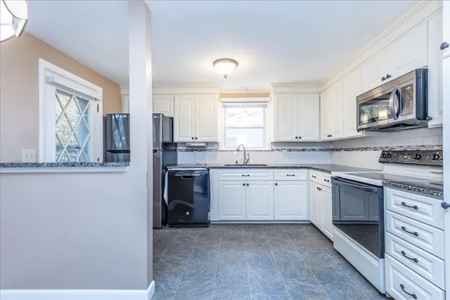 a kitchen with stainless steel appliances granite countertop a stove top oven a sink and dishwasher a refrigerator with wooden floor