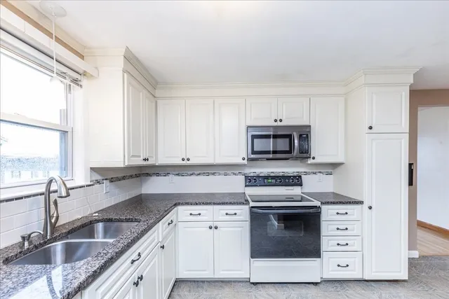 a kitchen with stainless steel appliances granite countertop a stove and a sink