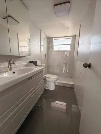 a bathroom with a double vanity sink a toilet and a mirror