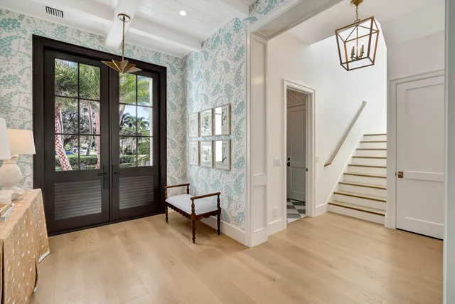 a view of an entryway with wooden floor and livingroom