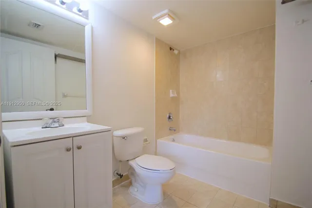 a bathroom with a bathtub shower sink mirror vanity and toilet