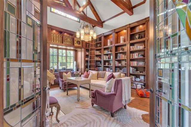 a living room with furniture a bookshelf and a large window