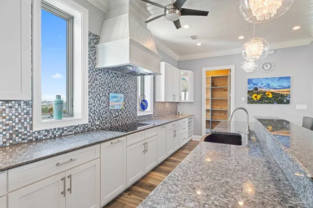 a large kitchen with kitchen island a large counter space a sink stainless steel appliances and cabinets