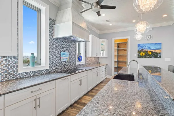 a large kitchen with kitchen island a large counter space a sink stainless steel appliances and cabinets