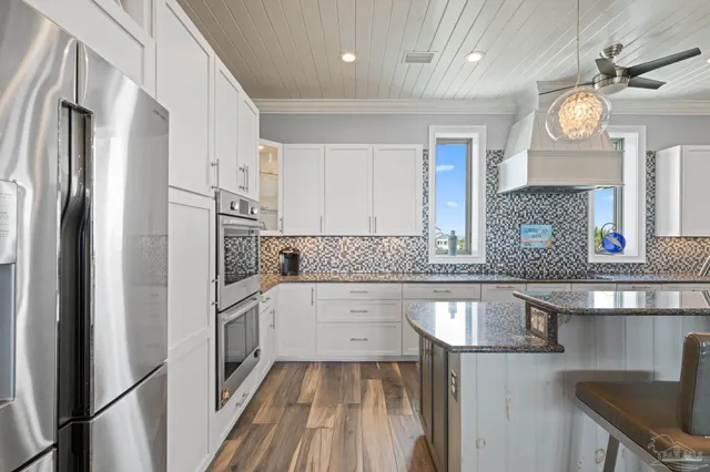 a bathroom with a granite countertop sink a toilet a large mirror and shower