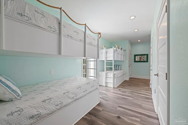 a spacious bedroom with a bed a mirror and lamp on desk