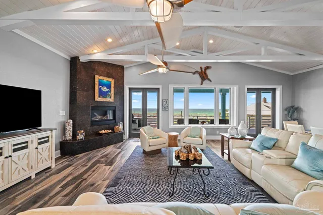 a living room with furniture a flat screen tv and a large window