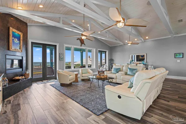 a living room with furniture kitchen view and a flat screen tv