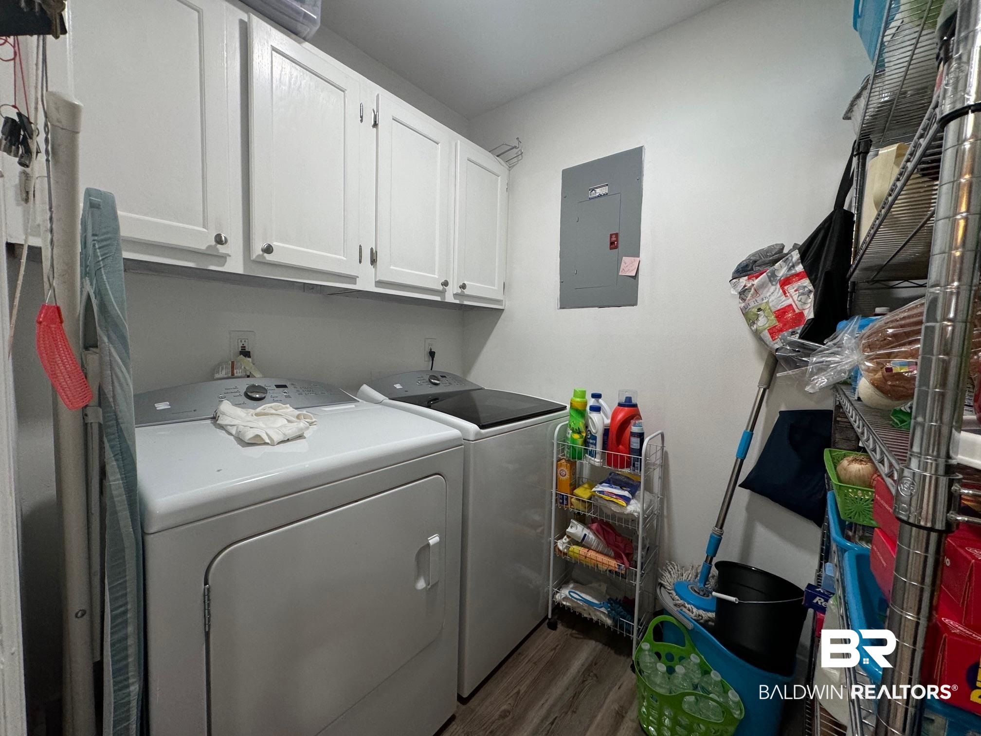 3200 Loop Road, Unit 55 Orange Beach, AL 36561 - Photo 11 of 40 Laundry area featuring electric panel, dark hardwood / wood-style floors, cabinets, and washer and clothes dryer