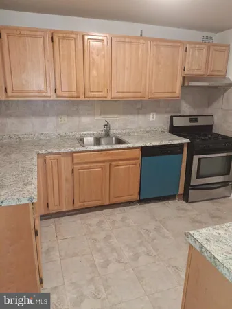 a kitchen with granite countertop a sink stove and cabinets