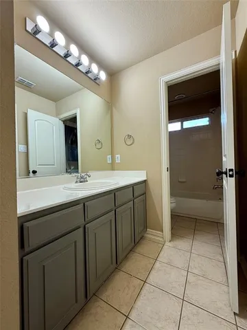 a bathroom with a granite countertop sink mirror and vanity