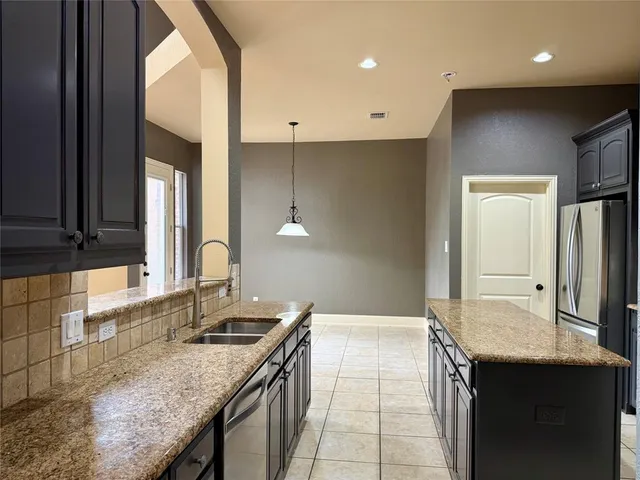 a bathroom with a granite countertop sink a mirror and a shower