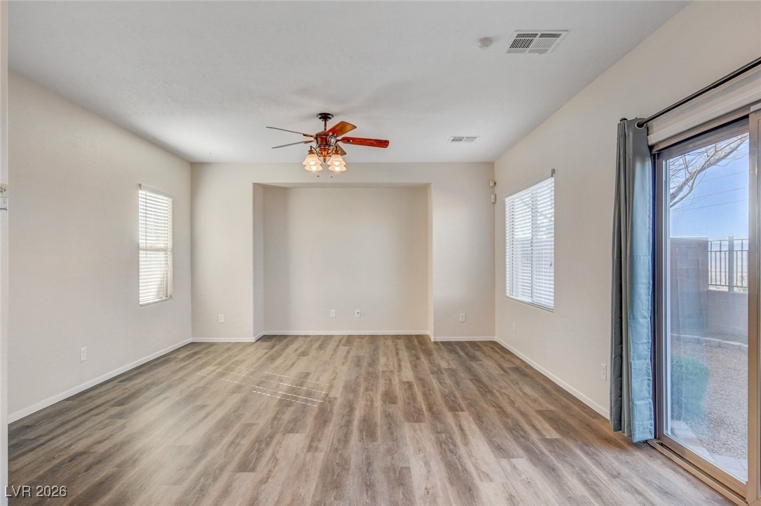 2460 Rue Bienville Way Henderson, NV 89044 - Photo 11 of 50 Empty room featuring light wood-style floors, a ceiling fan, and plenty of natural light