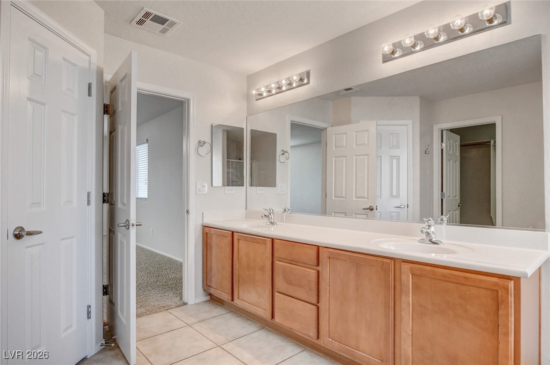 2460 Rue Bienville Way Henderson, NV 89044 - Photo 35 of 50 Bathroom with double vanity, light tile patterned floors, and light colored carpet