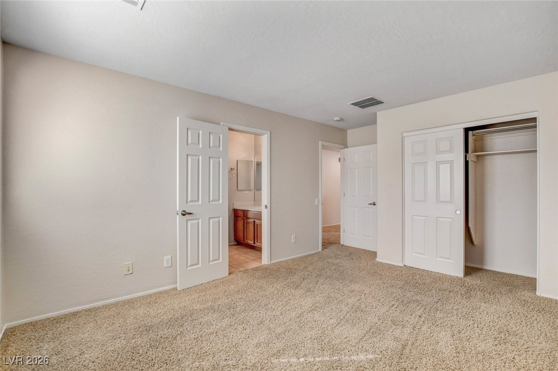 2460 Rue Bienville Way Henderson, NV 89044 - Photo 38 of 50 Unfurnished bedroom with a closet, connected bathroom, and light colored carpet