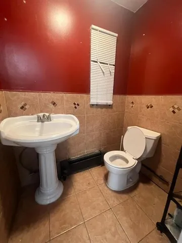 a bathroom with a sink toilet and mirror