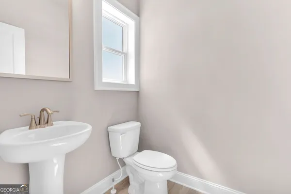 a bathroom with a sink a toilet and mirror