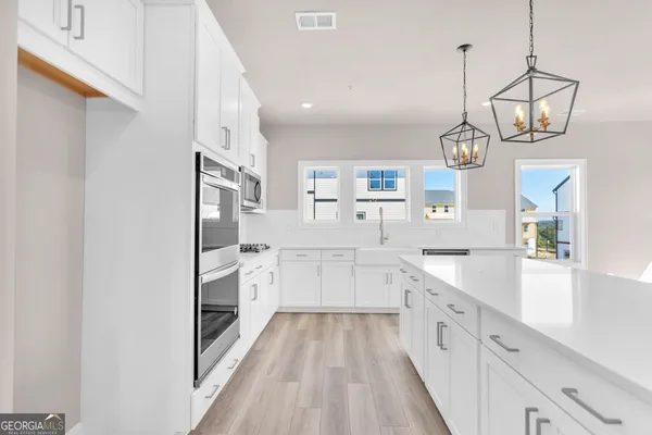 a large kitchen with a lot of counter space and wooden floor