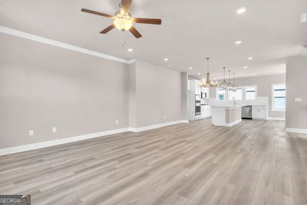 a view of an empty room and kitchen view