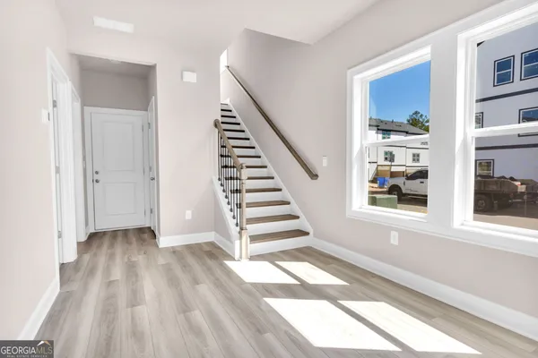 a view of a hallway with wooden floor and entryway