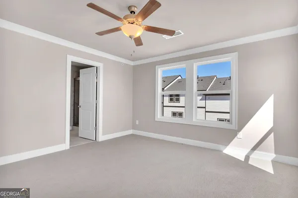 an empty room with windows and fan