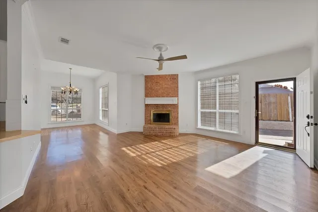 wooden floor fireplace and windows in an empty room