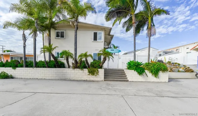 a front view of a house with plants