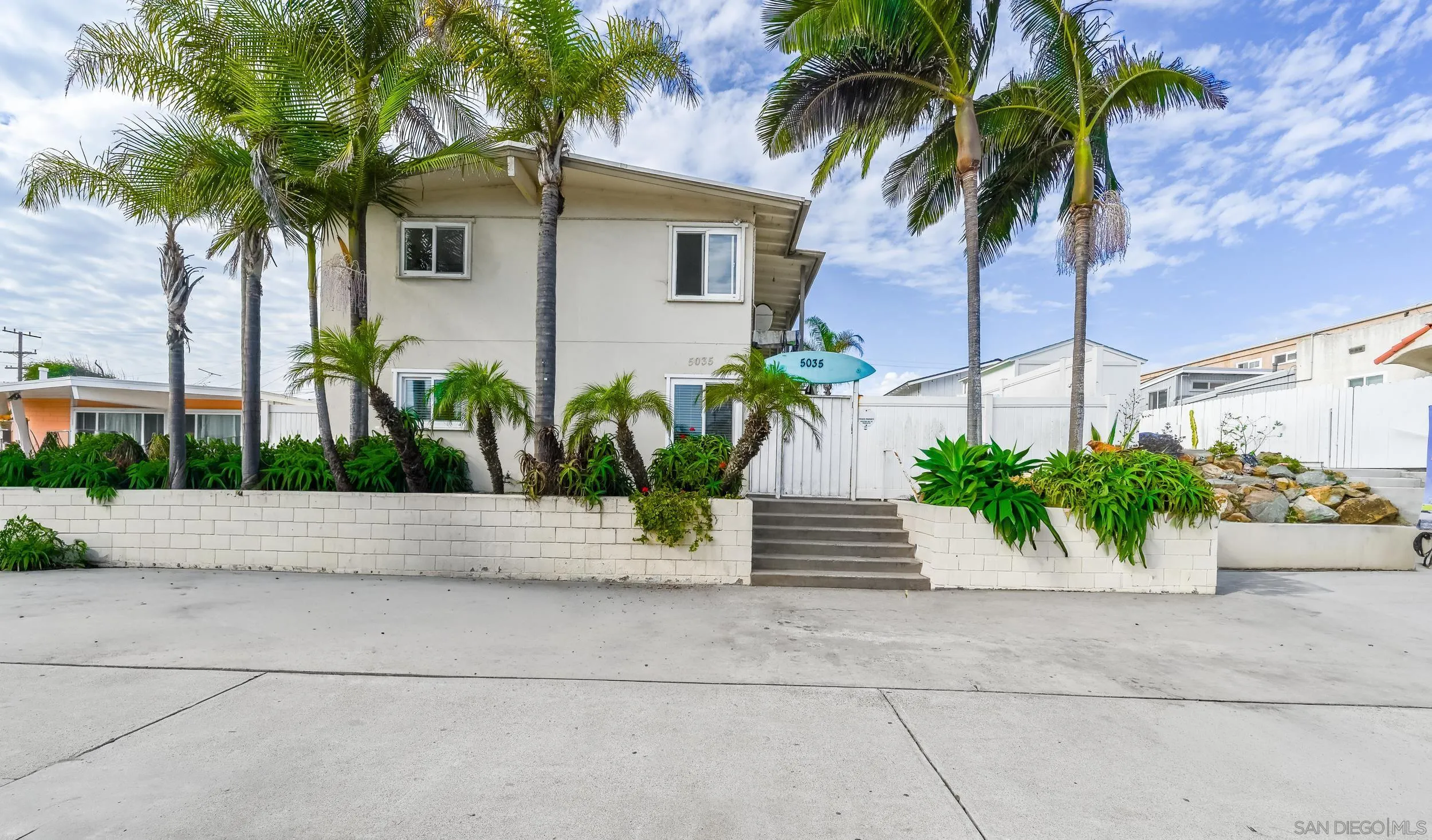 a front view of a house with plants