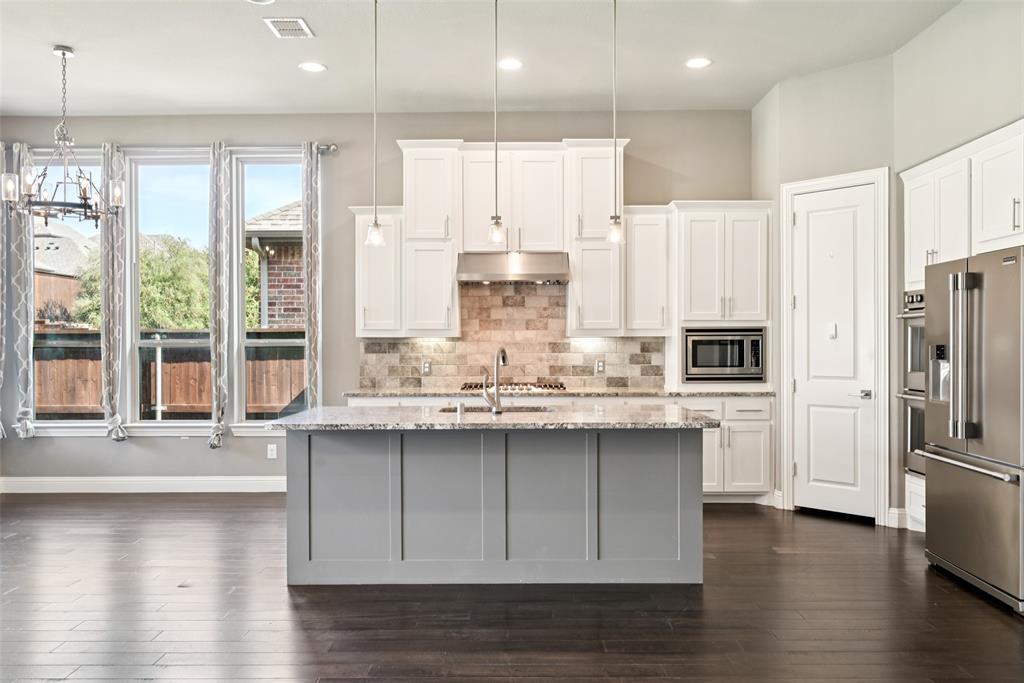3415 Secretariat Place Celina, TX 75009 - Photo 30 of 40 a kitchen with stainless steel appliances granite countertop a sink a stove and refrigerator