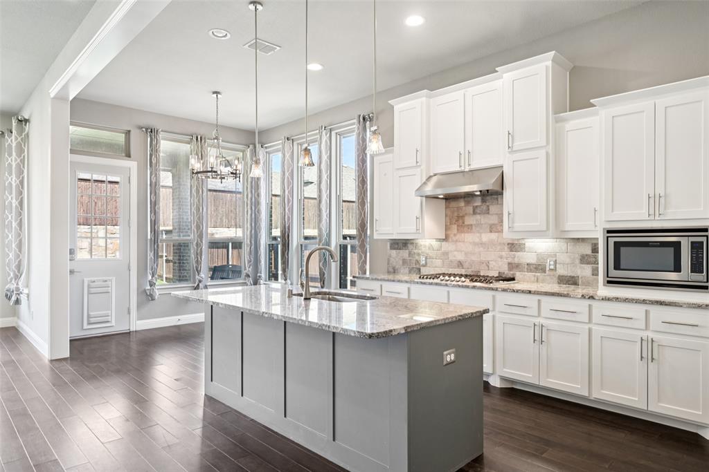 3415 Secretariat Place Celina, TX 75009 - Photo 31 of 40 a large white kitchen with stainless steel appliances granite countertop a lot of counter space and wooden floors